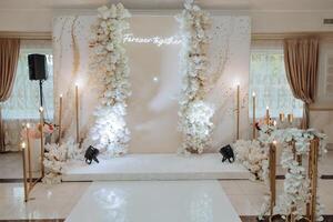 A white and gold wedding reception hall with a white archway photo