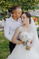 A bride and groom are hugging and kissing each other photo