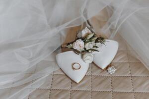 A wedding ring and a flower are on a bed photo