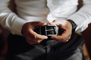 A man is holding a belt in his hands photo