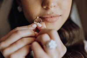 A woman is holding a ring in her hand, possibly getting ready to propose photo