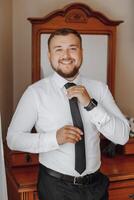 A man in a black tie is smiling and posing for a picture photo