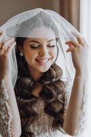 A woman with long hair is wearing a veil and smiling photo