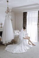 A bride is getting ready for her wedding and is sitting on a couch photo