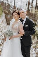 The bride and groom are walking in nature on their wedding day. A man hugs a woman. Wedding portrait photo
