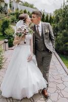 A bride and groom kiss in front of a white archway photo