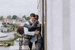 Two men hug each other on a balcony photo