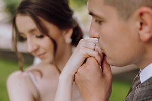 A man and a woman are holding hands, and the man is wearing a ring photo