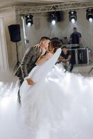 A bride and groom are kissing in the air at a wedding photo