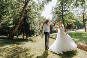 A bride and groom are dancing in a park photo