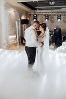 A bride and groom are dancing in the air with a foggy background photo