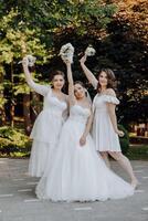 Three women in white dresses pose for a photo