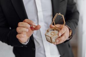 A man is holding a ring in his hand and a ring box photo