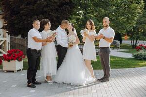 A group of people are posing for a picture, with a bride and groom in the center photo