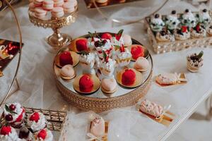 un mesa lleno de postres incluso pasteles, pastelitos, y pasteles foto