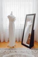 A white dress is standing in front of a mirror photo