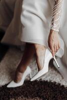 A woman is wearing a white dress and white high heels photo