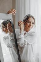 A woman is getting ready for a wedding and is looking at herself in a mirror photo