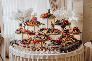 A table full of fruit and desserts with a white tablecloth photo