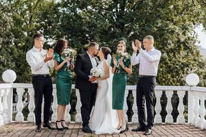 A group of people are posing for a picture, with a bride and groom in the center photo