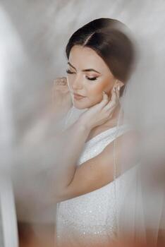 A woman is wearing a white dress and is looking at the camera photo