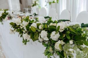 A table with white flowers and green leaves photo