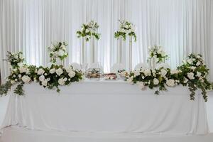 A table with white table cloth and white flowers on it photo