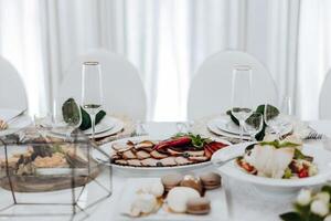 A table with a variety of food and drinks, including a plate of meat photo