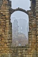 View through stone archway of ancient ruins in Tynemouth Priory and Castle photo