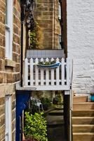 Narrow alleyway with balcony and boat-shaped planter in Robin Hood's Bay, Yorkshire photo