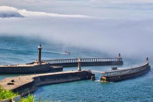 Coastal harbor with piers and lighthouses in Whitby, North Yorkshire photo