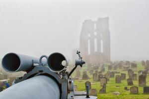 Foggy cemetery with cannon and ruins in Tynemouth Priory and Castle photo