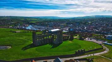 Aerial view of ancient abbey ruins and nearby town in Whitby, North Yorkshire photo