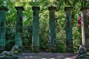 Ancient Stone Columns and Lion Statues in a Park photo