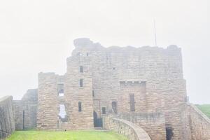 Foggy view of ancient stone castle ruin in Tynemouth Priory and Castle photo
