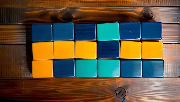 Top view of a partially solved Rubik's Cube on a wooden surface, showcasing a mix of blue and orange squares with a soft shadow cast, ideal for concepts of problem-solving and intelligence. photo