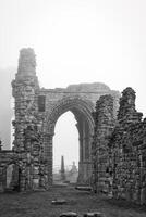 Ancient stone ruins in foggy weather in Tynemouth Priory and Castle photo