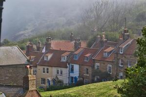 Traditional English Cottages on a Misty Hillside in Robin Hood's Bay, Yorkshire photo