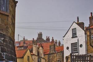 pintoresco pueblo con tejas rojas tejados y Roca casas Robin capucha bahía, Yorkshire foto