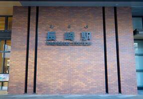Nagasaki, Japan - December 8, 2023 - Nagasaki Station sign on the red brick wall of the Kyushu Railway Company JR Kyushu Nagasaki Main Line photo