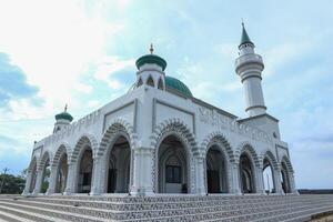 Beautiful white mosque in Ungaran, Indonesia with a blue sky background photo