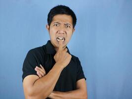 portrait of funny face expression of asian man surprised and biting finger. photo