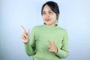 Portrait Asian beautiful young woman smiling standing pointing finger out on white background photo