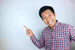 Asian man expression smiling while pointing to the side presenting the product. advertising concept photo