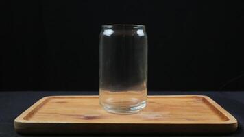 Empty glass cups and straws on wooden tray isolated on dark background photo