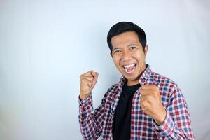yes, happy expression of asian man clenching his fists. victory concept, isolated white background photo