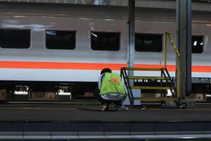 a train officer is controlling the tracks at an Indonesian railway station photo