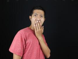 surprised amazed Asian man covering mout with hand palm looking staring at camera, shocked by news photo