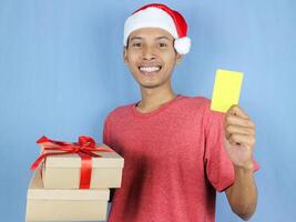 Happy excited asian man in new year's christmas day holding empty card and the present gift box photo