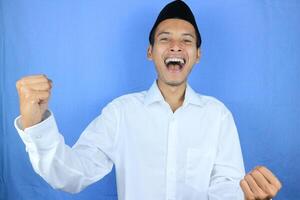 Yeah, I Did It. Portrait of overjoyed muslim asian man screaming with joy and clenched fists photo